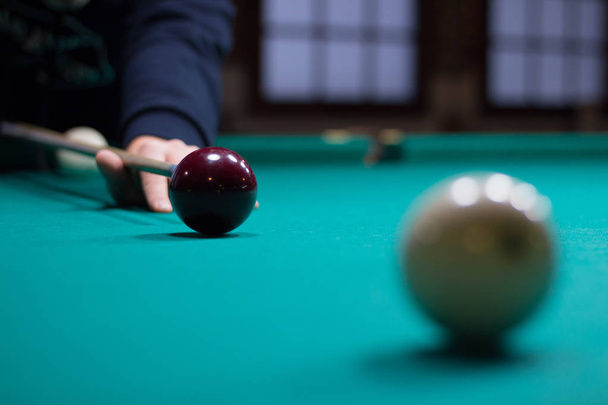 Russian billiards player aims to shoot black ball with cue - Photo, Image