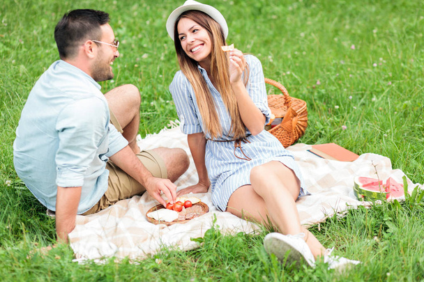 Прекрасная счастливая молодая пара наслаждается своим временем вместе на пикнике
 - Фото, изображение
