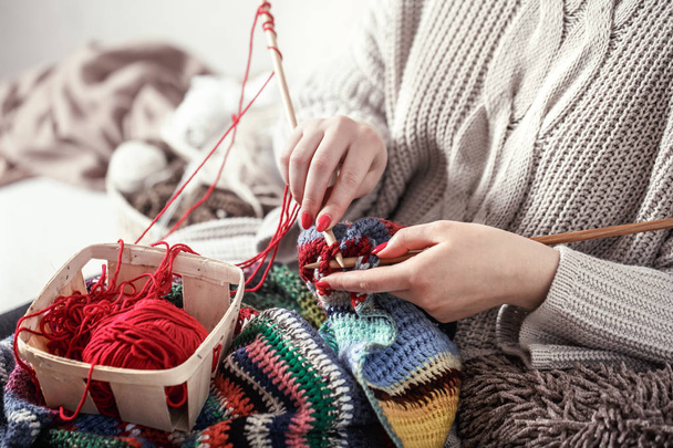 woman knits knitting needles on the couch - Valokuva, kuva