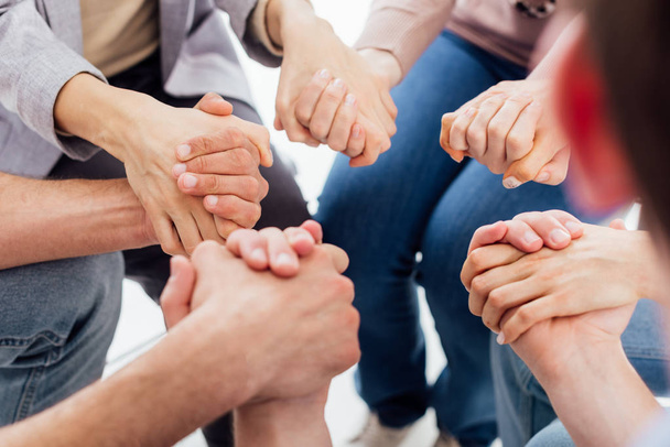 cropped view of people holding hands during group therapy session  - Photo, Image