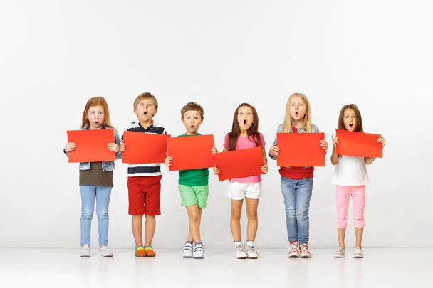 Group of children with red banners isolated in white - Foto, afbeelding