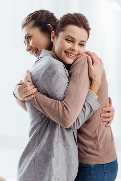 beautiful happy women embracing during therapy meeting - 写真・画像