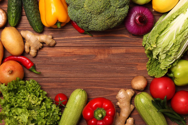 Διαφορετικά φρέσκα λαχανικά σε ένα ξύλινο τραπέζι πάνω όψη. Σωστή και υγιεινή διατροφή, διατροφή, χορτοφάγος. Μαγείρεμα τροφίμων, πιάτα λαχανικών. επίπεδη ωοτοκία - Φωτογραφία, εικόνα