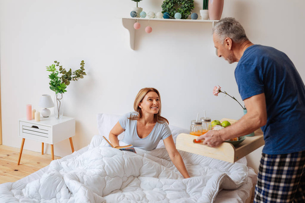 Wife having breakfast with husband in the bedroom after reading - Fotoğraf, Görsel