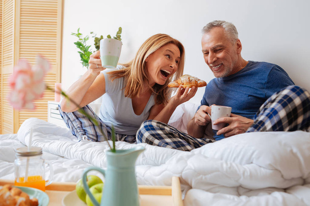 Couple having breakfast in bed eating yummy croissants - Fotografie, Obrázek