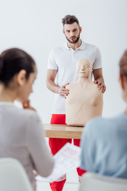 selective focus of instructor with cpr dummy during first aid training class - Foto, immagini