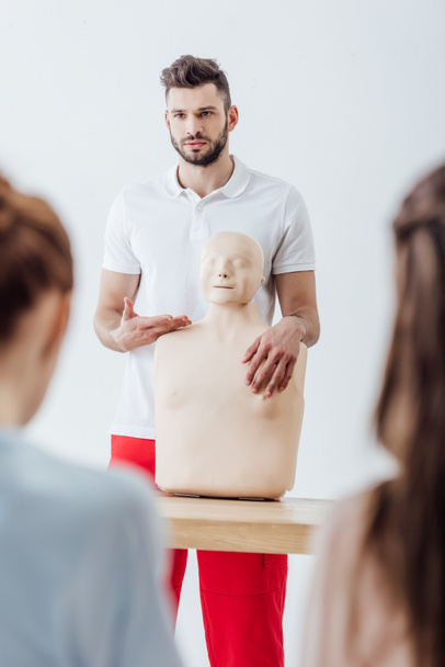 selective focus of instructor with cpr dummy during first aid training class - Foto, Bild
