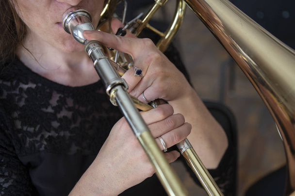 Hands of a girl playing the trombone - 写真・画像