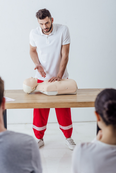 selective focus of handsome instructor gesturing during cpr training  - Photo, Image
