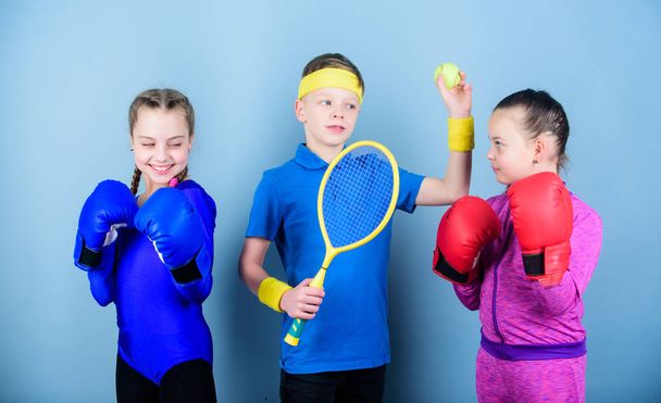 Friends ready for sport training. Sporty siblings. Child might excel completely different sport. Girls kids with boxing sport equipment and boy tennis player. Ways to help kids find sport they enjoy - Photo, Image