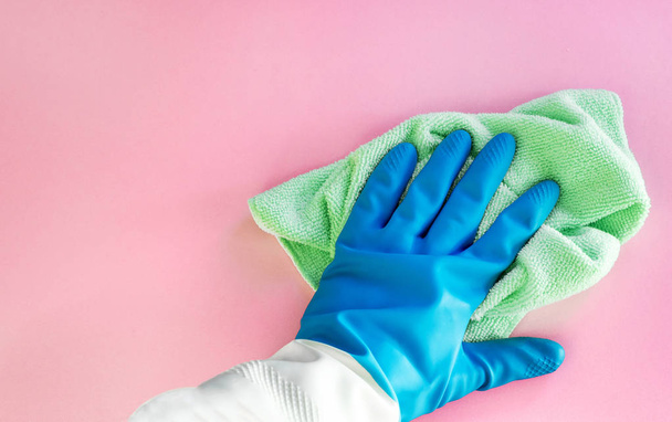 Employee hand in rubber protective glove with micro fiber cloth wiping wall from dust. Maid or housewife cares about house. Spring general or regular clean up. - Фото, зображення