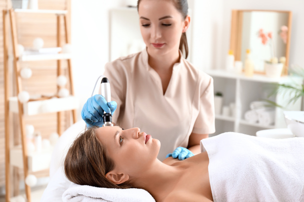 Young woman undergoing procedure of rf lifting in beauty salon - Foto, immagini