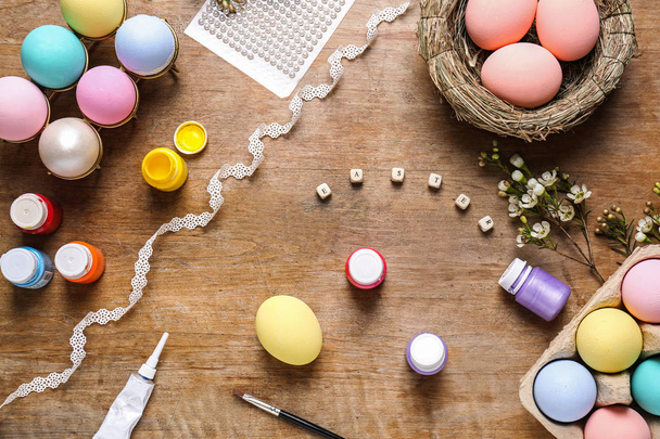 barevné velikonoční vajíčka a barvy na stůl - Fotografie, Obrázek