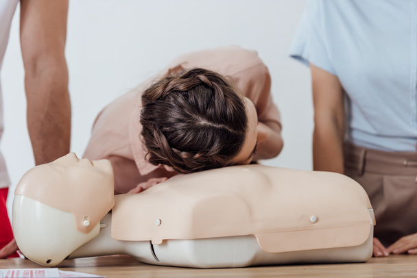 woman practicing cpr on dummy during first aid training class - Foto, Bild