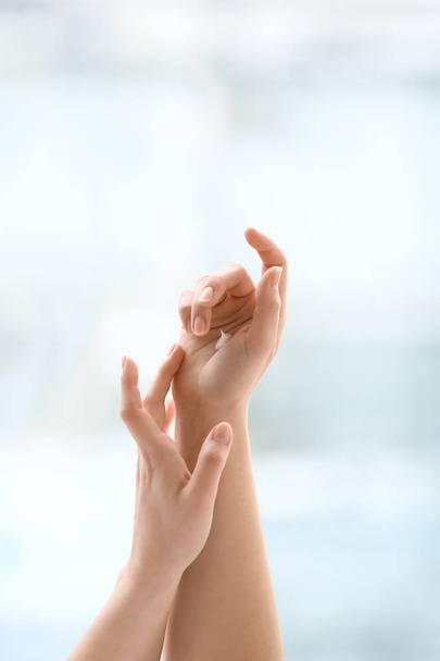 Руки молодой женщины наносят крем дома
 - Фото, изображение