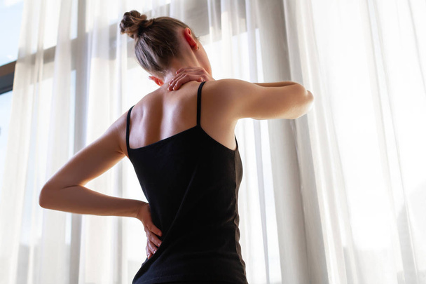 Young woman suffering from neck pain and backache, stretching the muscles at home. back and neck pain woman - Φωτογραφία, εικόνα
