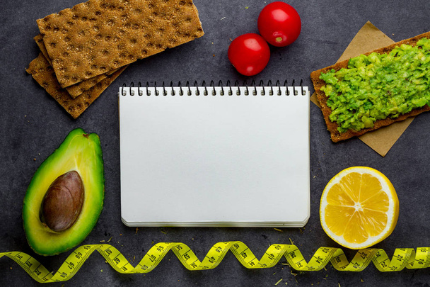 Crisp avocado sandwich with avocado cream and rye crisp bread for snack on a black background. Fiber food and fitness eating. Copy space. Top view. Diet concept  - Photo, Image