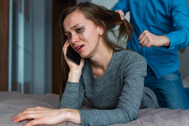 Female, domestic violence. Crying woman calling and asking for help during an argument with her husband and beating. Social problems, bad marriage. Social and life problems  - Photo, Image