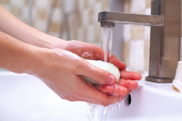 Hand hygiene. Person in the bathroom is cleaning and washing hands with soap. - Foto, Imagen