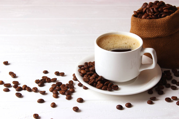 Egy csésze aromás kávé és kávébab fából készült háttérrel. Első látásra. Kávéital - Fotó, kép