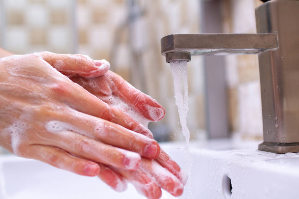 Гигиена рук. Человек в ванной комнате уборка и мытье рук с помощью мыла пены
 - Фото, изображение