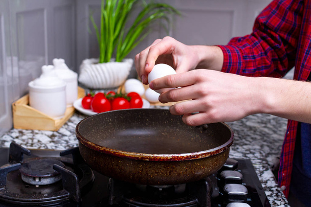 Freír huevos de pollo frescos y caseros en la sartén de la cocina en casa. Cocinar un desayuno saludable con proteínas
  - Foto, Imagen