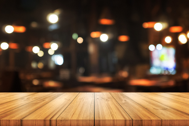 Lege houten tafelblad met wazig koffiewinkel of restaurant in - Foto, afbeelding
