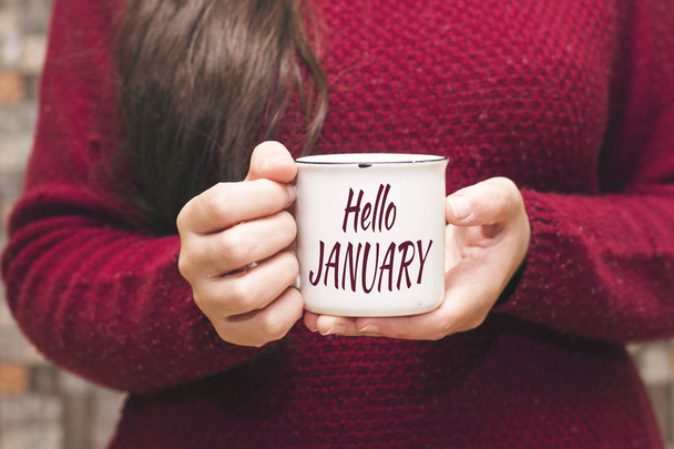 hello january text on cup and woman drinking a coffee - Photo, Image