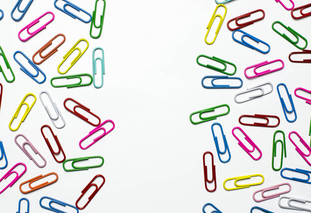 Colorful paper clips to documents lying on a white background - Photo, Image