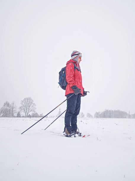 Smile face sports girl walk in snowshoes on snowy meadow - Photo, Image