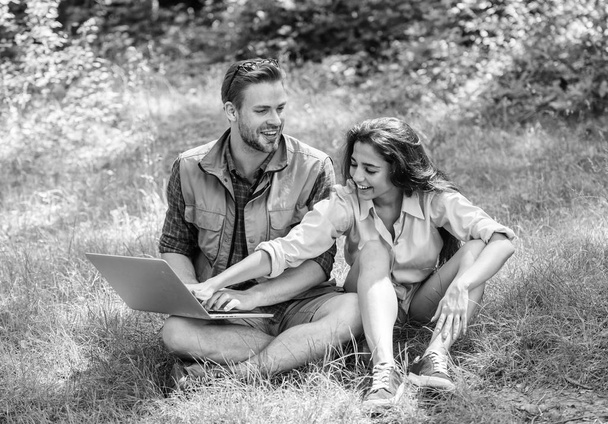 Couple youth spend leisure outdoors with laptop. Modern technologies give opportunity to be online and work in any environment conditions. Man and girl looking at laptop screen. Nature best workspace - Photo, image