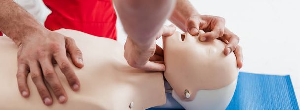 panoramic shot of men practicing cpr technique on dummy during first aid training - Foto, Bild