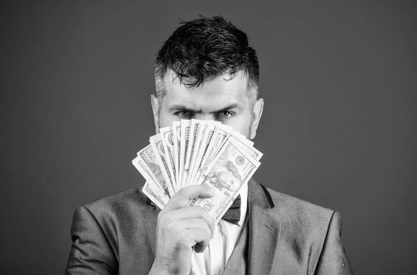 Get cash money easy and quickly. Smell of money. Easy cash loans. Man formal suit hold pile of dollar banknotes blue background. Businessman got cash money. Richness and wellbeing concept - Photo, Image