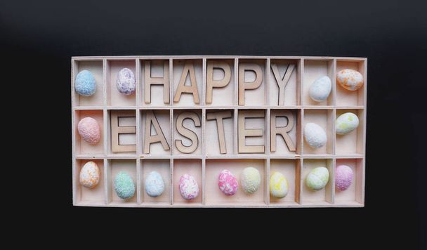 Easter eggs. Happy easter text. Holidays decoration black background - Fotografie, Obrázek