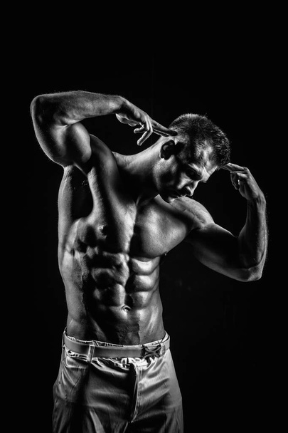 black and white shot of handsome muscular man isolated on black - Photo, image