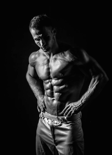 black and white shot of handsome muscular man isolated on black - Фото, зображення