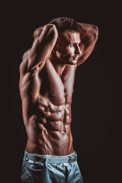 handsome muscular man isolated on black - Fotoğraf, Görsel
