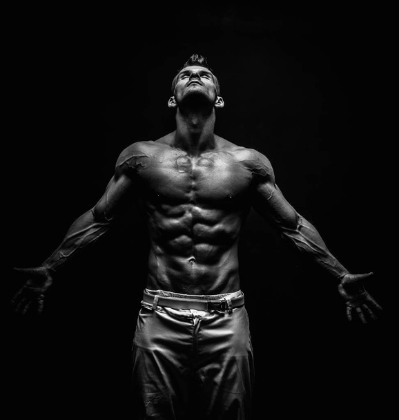black and white shot of handsome muscular man isolated on black - Φωτογραφία, εικόνα