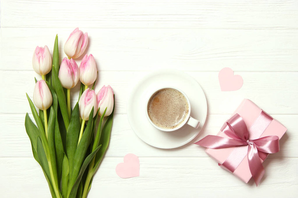 bukiet pięknych tulipanów, prezent i kawa na drewnianym tle widok z góry. Tło Dnia Matki, Międzynarodowy Dzień Kobiet, Urodziny. Holiday, daj prezent.. - Zdjęcie, obraz