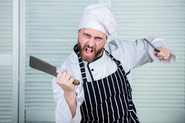 Chef with knifes. Professional in kitchen. culinary cuisine. angry bearded man with knife. love eating food. confident man in apron and hat. cook in restaurant, uniform. chef ready for cooking - Foto, Imagem