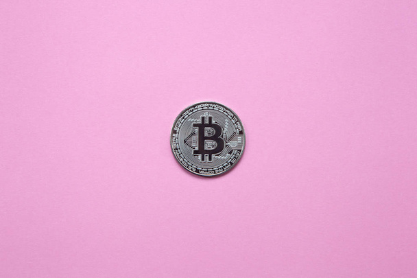 Silver bitcoin on a millennial pink background. Top view. Minimalism. Horizontal orientation - Photo, image
