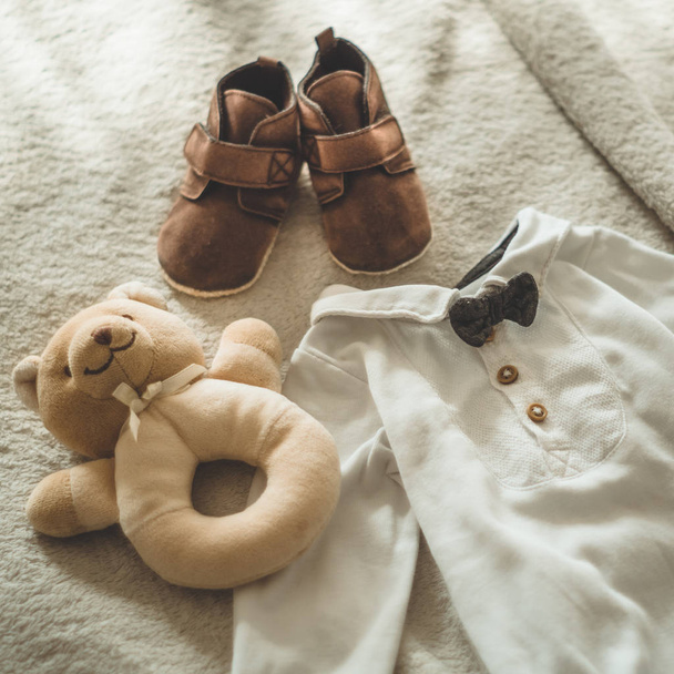 Trochę ręcznie wykonane ubrania dla dzieci. Zdjęcie z USG. Newborn Odzież na beżowym tle wełniane - Zdjęcie, obraz