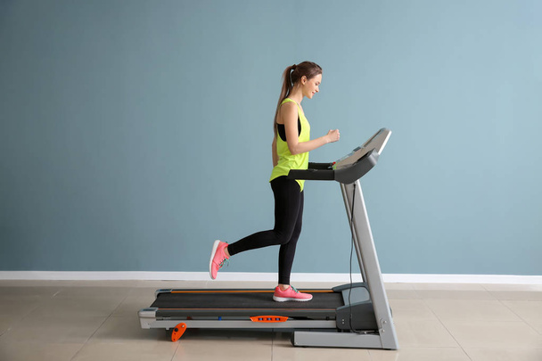 Sporty young woman training on treadmill in gym - Foto, afbeelding