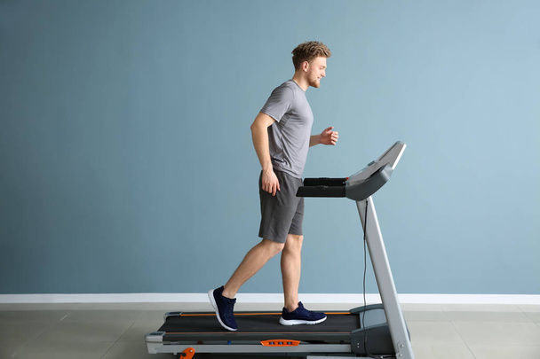 Sporty young man training on treadmill in gym - Foto, immagini