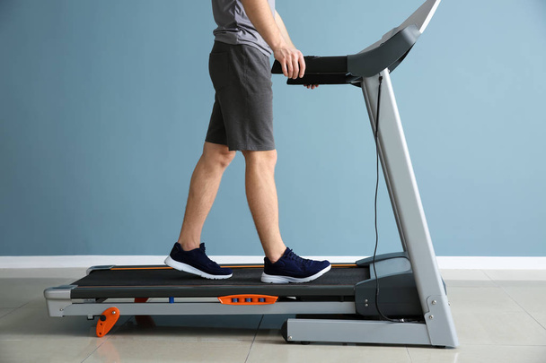 Sporty young man training on treadmill in gym - Photo, Image