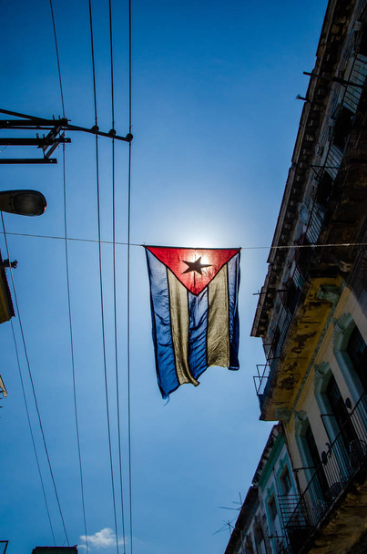 Cuban flag hangs in a street of the working-class neighborhood of Central Havana - Photo, Image