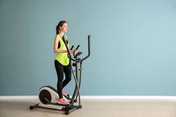 Sporty young woman training on machine in gym - Fotografie, Obrázek