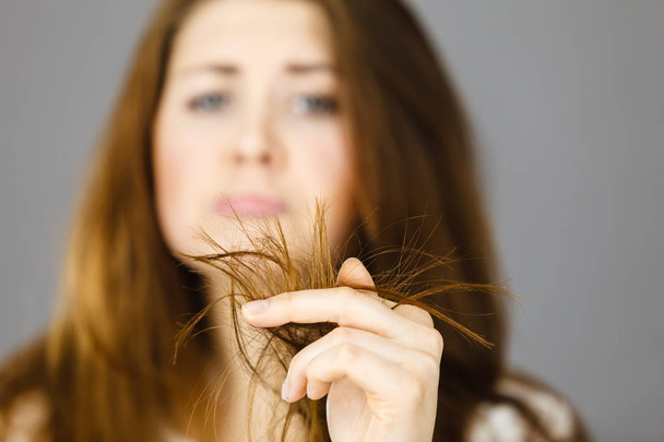 Femme inquiète regardant ses cheveux secs se termine
 - Photo, image