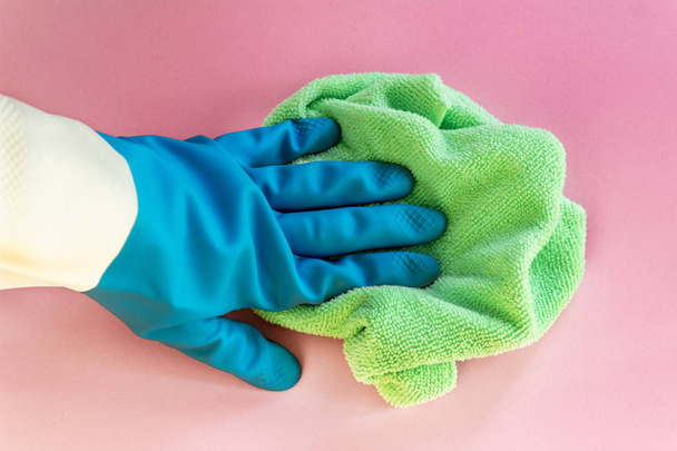 Home disinfecting. Safe and efficient cleaning. hand in rubber glove with rag. Flat lay, close up on pink background. - Φωτογραφία, εικόνα