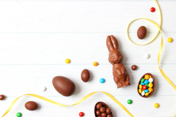 Paskalya kompozisyonu çikolatalı yumurtalar ve ahşap arka planda çikolatalı tavşan, mesaj için yer  - Fotoğraf, Görsel